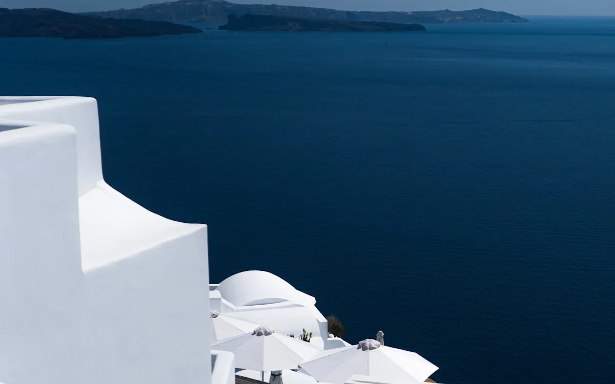 A sweeping view of the deep blue sea from a white-washed terrace in Santorini